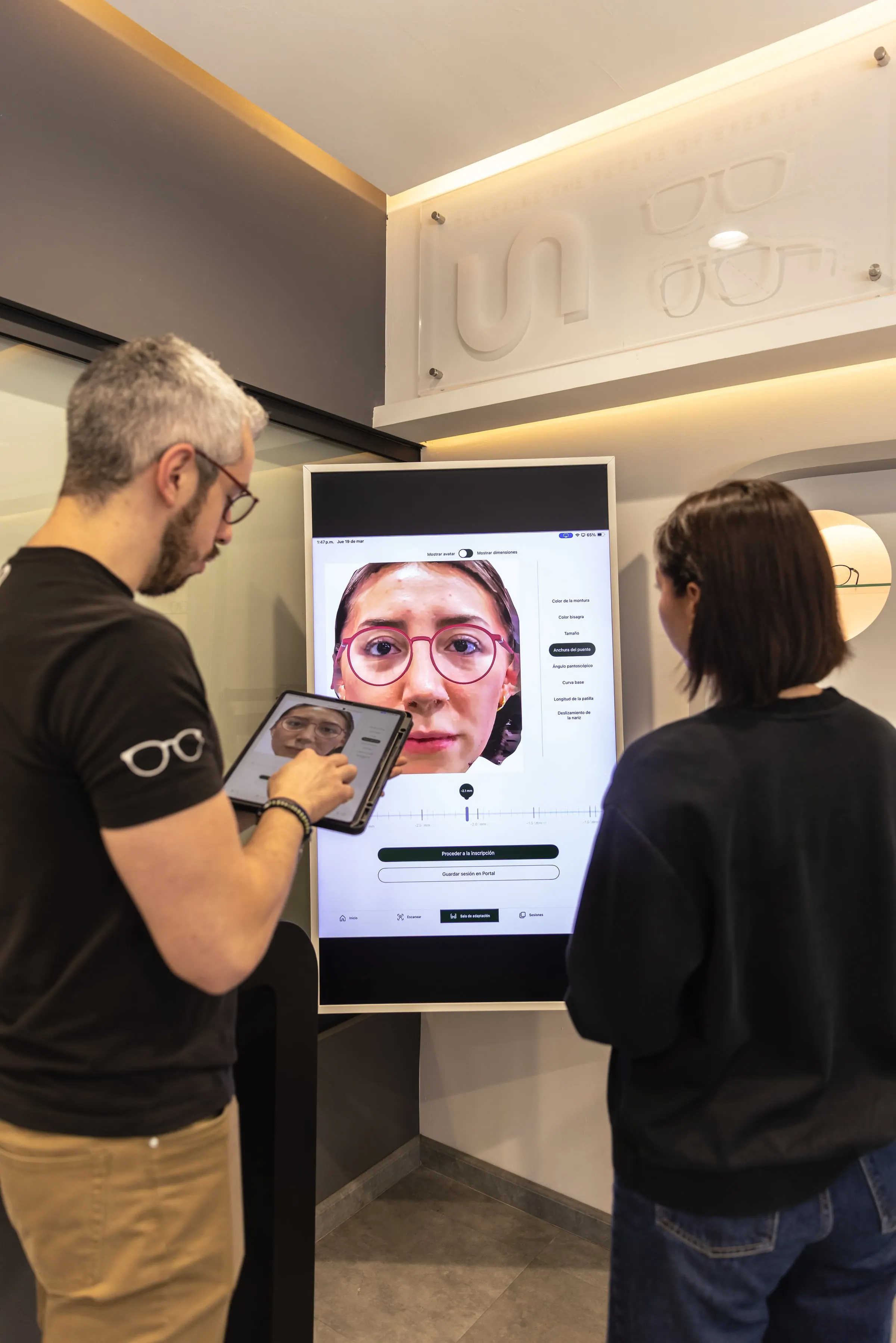 Asesor de iunok y clienta frente a la pantalla de escaneo facial